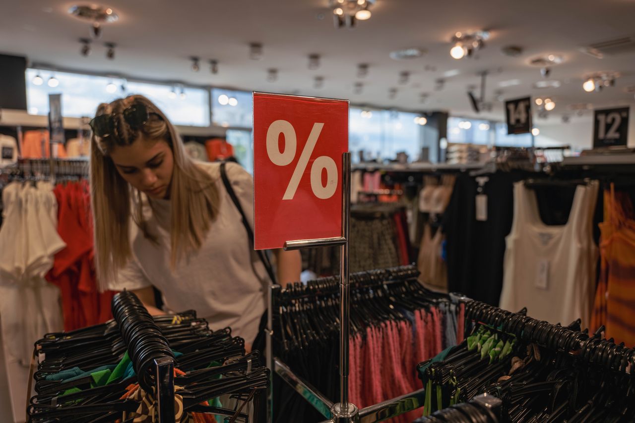 Panneau de remise en pourcentage dans un rayon de vêtements pendant les soldes en magasin